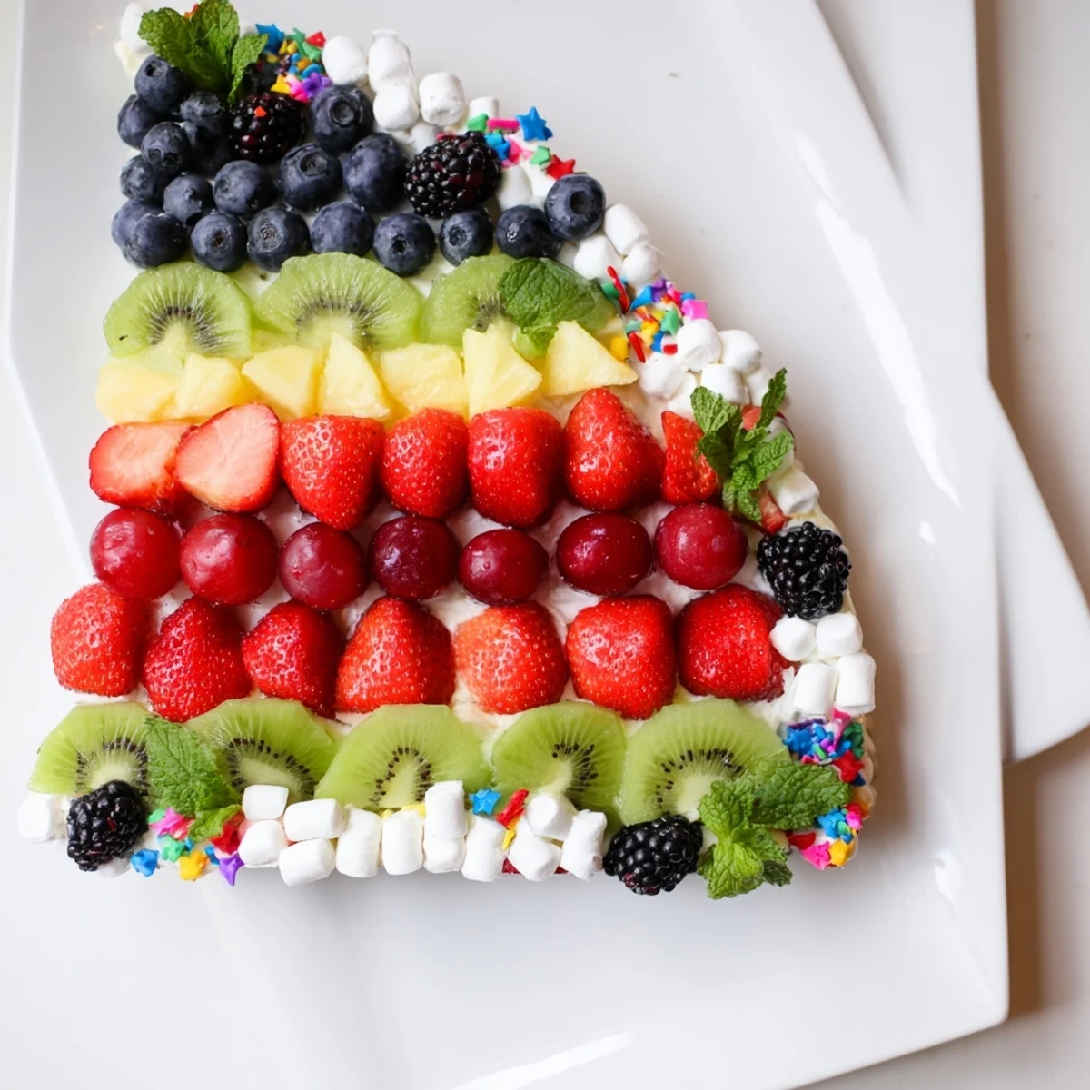 See a close-up of the Happy Birthday Cake Slice Fruit Board, showcasing fresh fruit layers and sweet marshmallow frosting details.