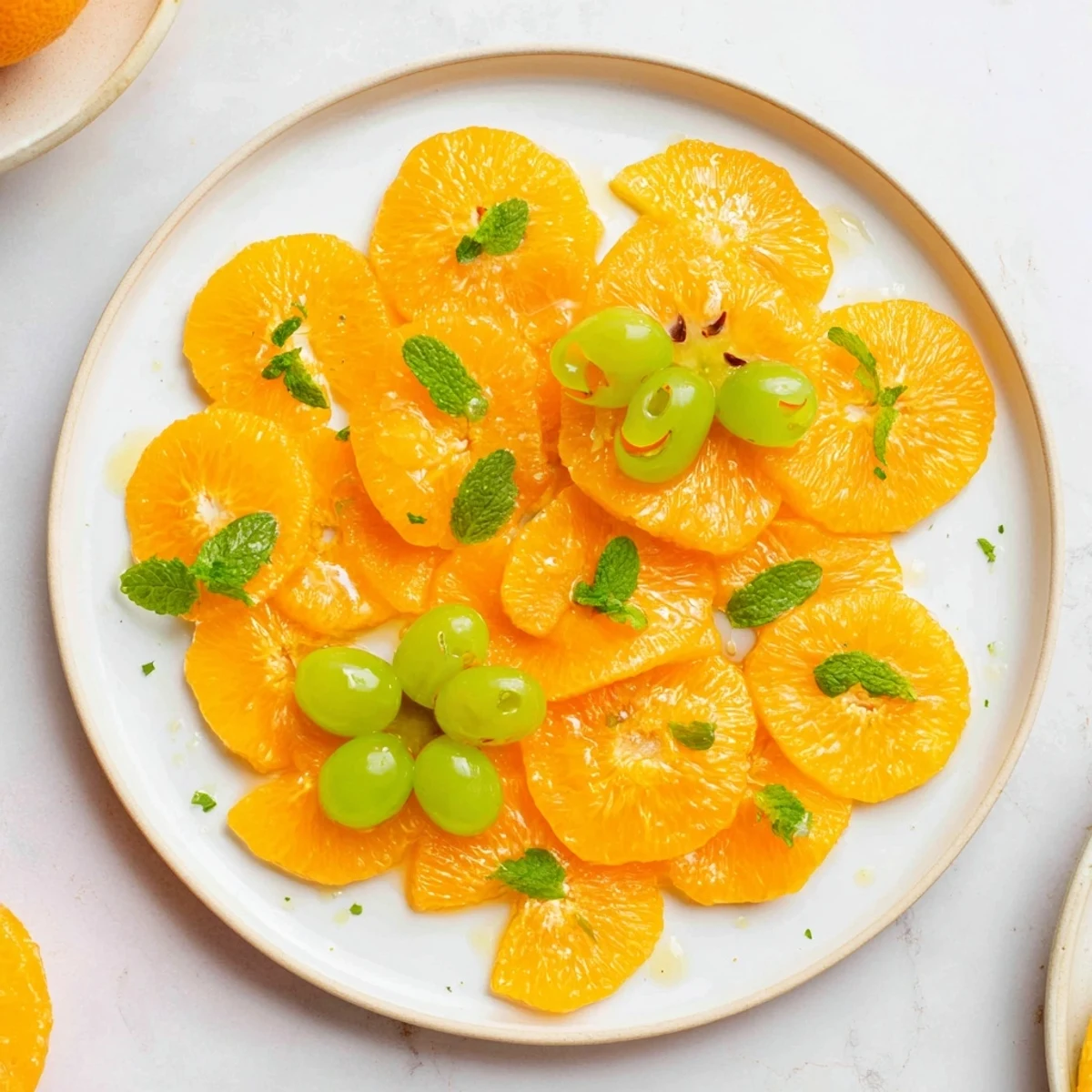 Close-up of bright orange slices decorated like pumpkins, a fun and easy Halloween treat idea.