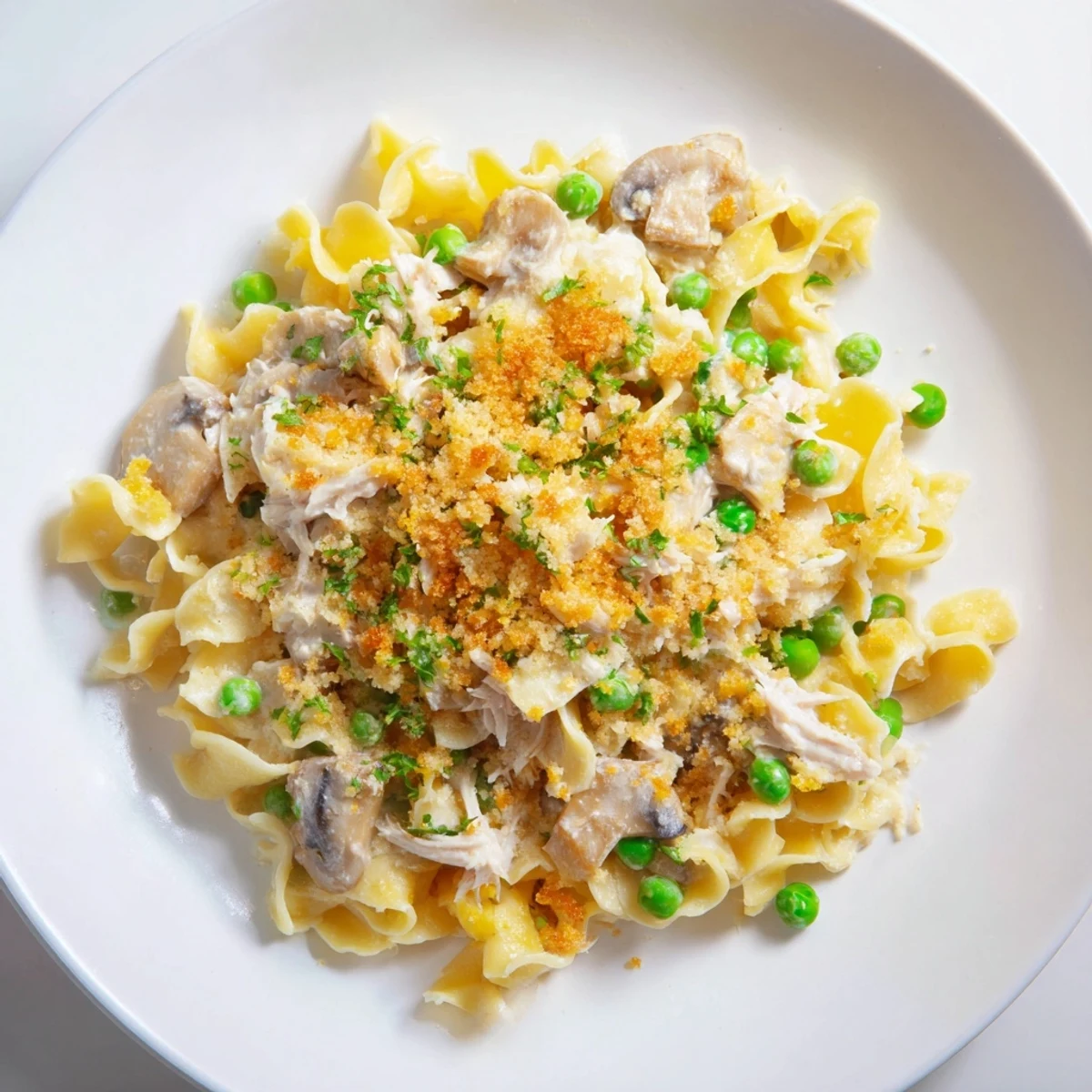 Golden-topped tuna noodle casserole 2.0, brimming with creamy sauce and colorful vegetables, ready to serve.