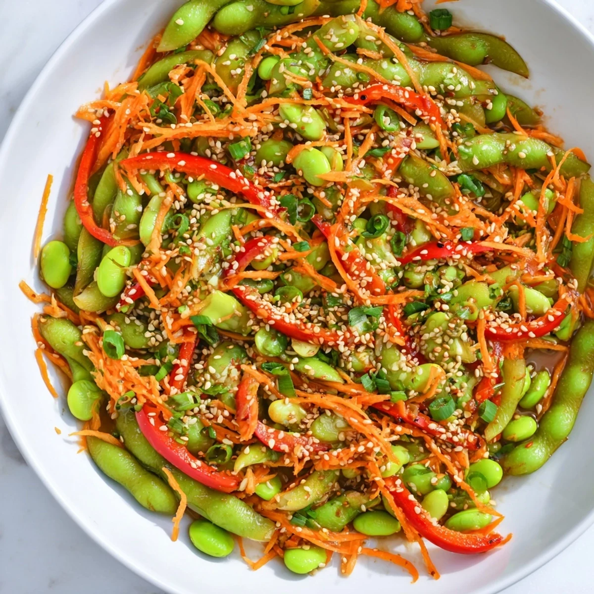 Vibrant Asian edamame salad tossed in sesame ginger dressing, a quick and easy lunchtime meal.