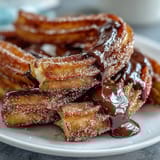 Crispy cinnamon sugar churro bites, golden and warm, served with a velvety chocolate dipping sauce for a festive Cinco de Mayo dessert.