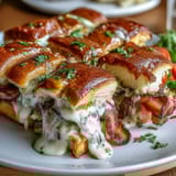 Golden-baked mini Hot Brown sandwiches on brioche, featuring roast turkey, tomato, and melted cheese Mornay sauce.  