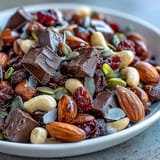 A vibrant bowl of Homemade Trail Mix with Dark Chocolate, combining roasted nuts, chewy cranberries, and rich cocoa chunks for a satisfying treat.