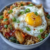 Flavorful Fermented Cabbage Kimchi Fried Rice Bowl with vibrant green onions and carrots.