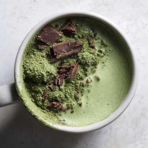 Steaming Matcha Peppermint Brownie Batter Mug Cake, a quick, single-serve dessert, ready in a warm mug.