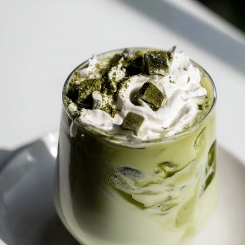 Creamy sugar-free white chocolate candy cane iced matcha, layered drink ready to enjoy for the holidays.
