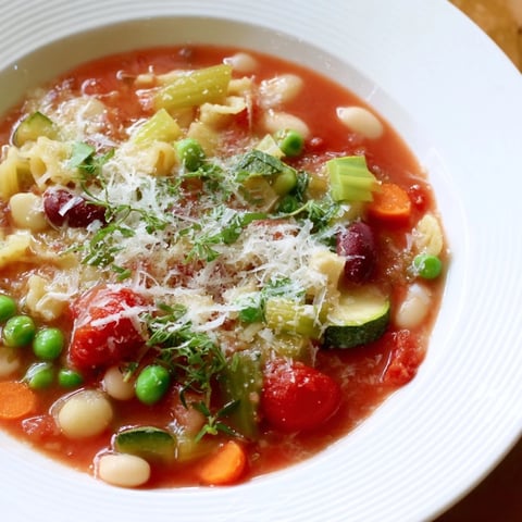 Steaming bowl of Veggie-Packed Minestrone Christmas Pasta Pot, ready to warm you up with vibrant ingredients.