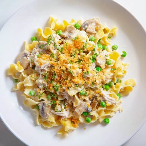 Golden-topped tuna noodle casserole 2.0, brimming with creamy sauce and colorful vegetables, ready to serve.