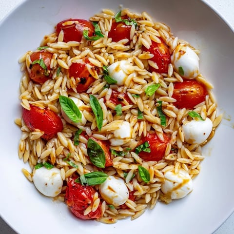 Vibrant Caprese Orzo Salad featuring ripe tomatoes and creamy mozzarella, drizzled with tangy balsamic.