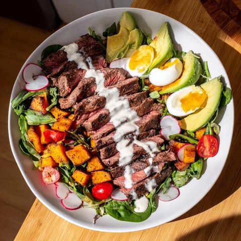 High-Protein Beef Avocado Bowl showcasing tender beef slices atop vibrant salad greens and creamy avocado.