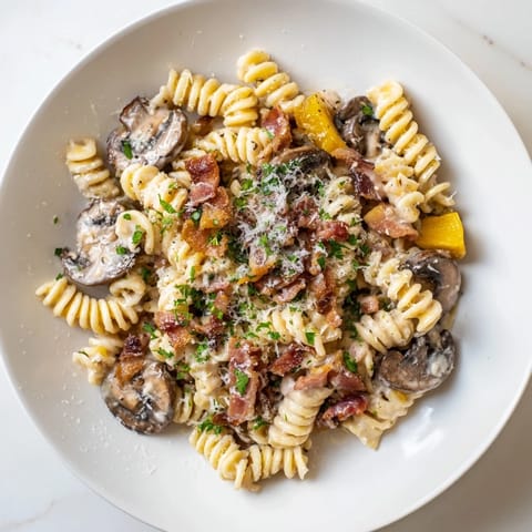 Savory fusilli with bacon, onions, and mushrooms, a comforting Italian-inspired dinner.