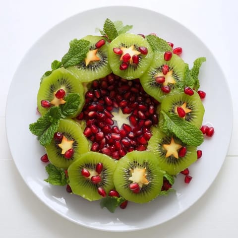 A beautiful, fresh fruit Kiwi and Pomegranate Christmas wreath, a healthy holiday treat brimming with sweet flavors.