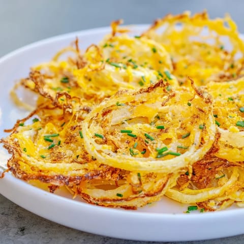 Air fryer's perfect Crispy Onion Cheese Chips: crispy, cheesy, and spiced to perfection for snack time.