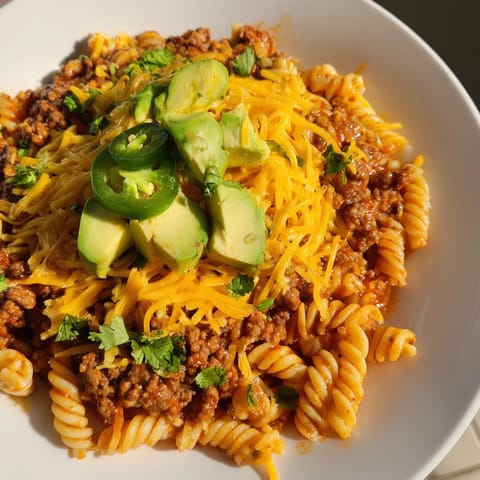 A close-up of a sizzling Beef Taco Pasta Skillet, featuring tender pasta and savory beef.