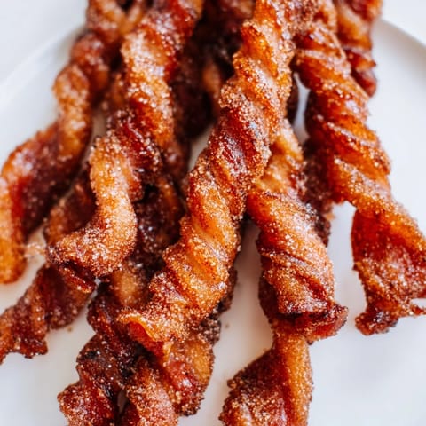Sweet and savory Spiced Bacon Twists cooling slightly, perfect for brunch platters or holiday parties.