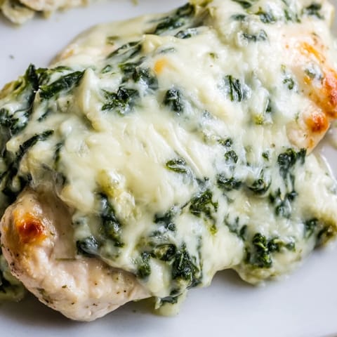 Tender chicken breasts baked under a golden spinach and artichoke yogurt topping, perfect for weeknights.