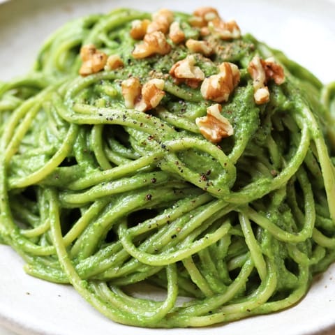 Plate of Creamy Spinach Walnut Pasta twirled on a fork, showcasing the rich, dairy-free sauce for a weeknight vegan dinner.