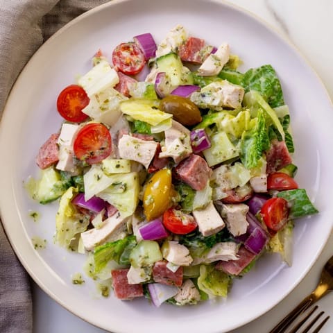 Colorful Italian Deli Chopped Chicken Salad features chopped salami, provolone, and pepperoncini scattered over fresh greens for a zesty main dish.  