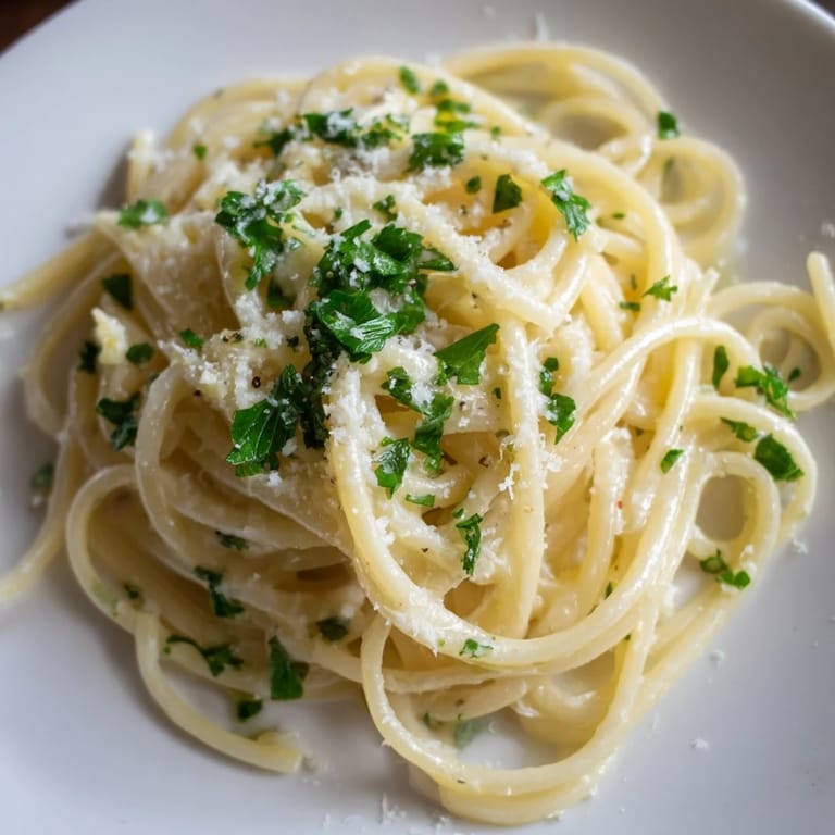 Close-up of golden Garlic Butter Linguine, showing the fresh parsley and a delicate, flavorful pasta meal.