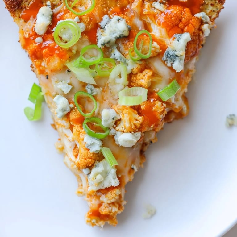 Sizzling Buffalo Cauliflower Pizza fresh from the oven, featuring a gluten-free cauliflower crust and tangy buffalo toppings.