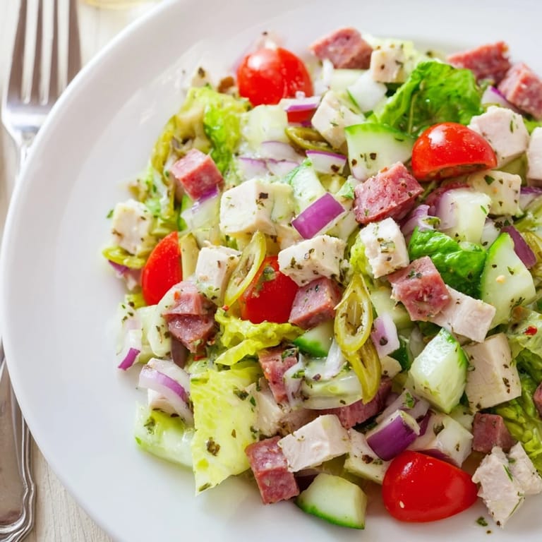 Bright, overhead view of Italian Deli Chopped Chicken Salad tossed with red onion and cucumber, ready to serve as a gluten-free lunch.