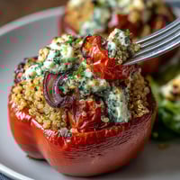 Colorful quinoa stuffed bell peppers baked with roasted vegetables and creamy goat cheese for a healthy, satisfying meal.  